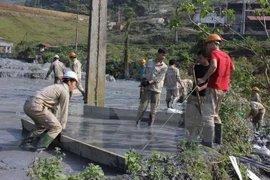 Công nhân nhà máy chì kẽm thu gom chất bùn thải đưa trả lại hồ chứa. (Ảnh: Quốc Đạt/TTXVN)