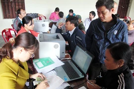 Các hộ gia đình làm thủ tục vay vốn tín dụng học sinh, sinh viên tại điểm giao dịch xã Yên Phong, Ninh Bình. (Ảnh: Văn Đạt/TTXVN)