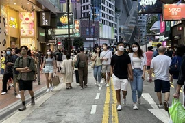 Người dân đi mua sắm tại khu vực Causeway Bay. (Ảnh: Mạc Luyện/TTXVN)