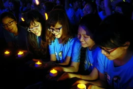 Các tình nguyện viên tại Thành phố Hồ Chí Minh thắp đèn led, hưởng ứng chiến dịch Giờ Trái đất Xanh (Ảnh: Mạnh Linh/TTXVN)