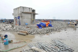 Thực hiện phá dỡ phần công trình xây dựng sai phạm tại tòa nhà 8B Lê Trực. (Ảnh: Minh Đức/TTXVN)