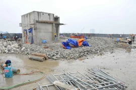 Thực hiện phá dỡ phần công trình xây dựng sai phạm tại tòa nhà 8B Lê Trực. (Ảnh: Minh Đức/TTXVN)