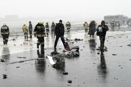 Lực lượng chức năng điều tra tại hiện trường ngổn ngang mảnh vỡ máy bay sau vụ tai nạn tại Rostov-on-Don. (Nguồn: AFP/TTXVN)