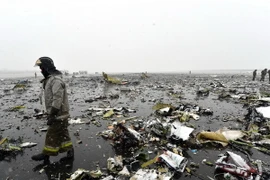 Lực lượng chức năng điều tra tại hiện trường ngổn ngang mảnh vỡ máy bay sau vụ tai nạn tại Rostov-on-Don. (Nguồn: AFP/TTXVN)