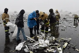 Lực lượng chức năng điều tra tại hiện trường ngổn ngang mảnh vỡ máy bay sau vụ tai nạn tại Rostov-on-Don. (Nguồn: AFP/TTXVN)