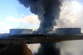 Khói bốc lên từ một kho dự trữ dầu tại nhà máy lọc dầu ở Ras Lanouf, Lybia ngày 23/1 sau các cuộc tấn công của IS. (Nguồn: AFP/TTXVN)