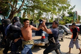 Cảnh sát địa phương bắt giữ những đối tượng gây bạo loạn tại Acapulco, bang Guerrero, Mexico. (Nguồn: AFP/TTXVN)