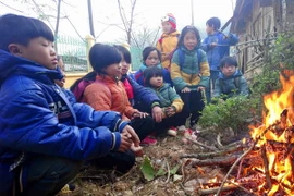 Học sinh trường tiểu học Yên Lạc, huyện Nguyên Bình (Cao Bằng) co ro bên đống lửa. (Ảnh: Quốc Đạt/TTXVN)