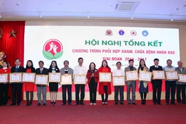 Chủ tịch Trung ương Hội Chữ thập Đỏ Việt Nam Nguyễn Thị Xuân Thu trao Bằng khen cho các tập thể cá nhân đã có thành tích xuất sắc trong chương trình Khám, chữa bệnh nhân đạo và chăm sóc sức khỏe cộng đồng. (Ảnh: Quý Trung/TTXVN)