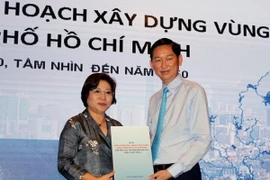 Thứ trưởng Bộ Xây Dựng Phan Thị Mỹ Linh trao tài liệu Điều chỉnh quy hoạch xây dựng vùng cho Phó Chủ tịch UBND thành phố Hồ Chí Minh Trần Vĩnh Tuyến. (Ảnh: Hoàng Hải/TTXVN)