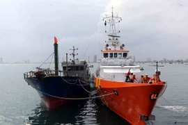 Tàu SAR 412 lai dắt tàu cá QB 91386 TS cùng 11 ngư dân bị nạn trên biển về bờ an toàn tại Đà Nẵng. (Ảnh: Trần Lê Lâm/TTXVN)