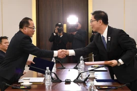 Trưởng đoàn đàm phán Hàn Quốc, Thứ trưởng Bộ Thống nhất Chun Hae-sung (phải) và Trưởng đại diện đàm phán Triều Tiên, Phó Chủ tịch Ủy ban tái thống nhất hòa bình Jon Jong Su (trái) trao đổi văn kiện tại cuộc đàm phán ở làng đình chiến Panmunjom. (Nguồn: TH