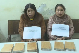 Hai đối tượng Lầu Thị Dua và Thào Thị Dợ cùng tang vật. (Ảnh: Nguyễn Cường/TTXVN)