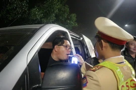 Cảnh sát giao thông đo nồng độ cồn người điều khiển phương tiện giao thông. (Ảnh: Hoàng Ngà/TTXVN)