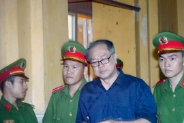 Dẫn giải bị cáo Phạm Công Danh ra xét xử tại phiên tòa. (Ảnh: Hoàng Hải/TTXVN)