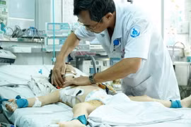 Khám cho bệnh nhi bị hai con chó cắn thủng khí quản. (Ảnh: Phương Vy/TTXVN)