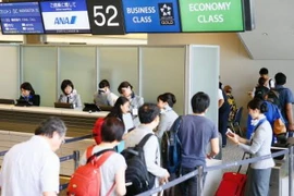 Hành khách làm thủ tục lên máy bay tại sân bay Narita, Nhật Bản. (Nguồn: Kyodo/TTXVN)