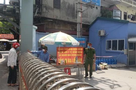 Lực lượng chức năng trực kiểm soát tại cổng vào Bệnh viện Đa khoa khu vực Phúc Yên, thành phố Phúc Yên. (Ảnh: Hoàng Hùng/TTXVN)