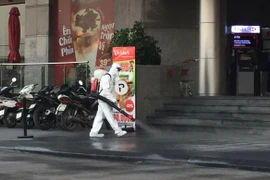 Lực lượng y tế quận Tây Hồ tiến hành phun khử khuẩn tòa nhà Fraser Suites. (Ảnh: Thành Đạt/TTXVN)