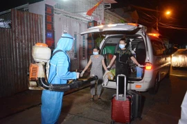 Lực lượng chức năng đưa F1 của trường hợp dương tính với virus SARS-CoV-2 đi cách ly tập trung. (Ảnh: Tuấn Anh/TTXVN)