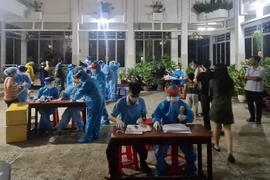 Lực lượng y tế lấy mẫu xét nghiệm COVID-19 cho người dân phường 15, quận Gò Vấp trong đêm 28/5, rạng sáng 29/5. (Ảnh: TTXVN phát)
