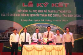 Lãnh đạo Sở Văn hóa-Thể thao và Du lịch Long An và lãnh đạo Tập đoàn Hoàn Cầu ký kết hợp đồng tài trợ. (Ảnh: Thanh Bình/TTXVN)