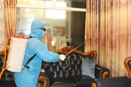 Lực lượng chức năng tiến hành phun khử khuẩn tại nhà các bệnh nhân. (Ảnh: TTXVN phát)