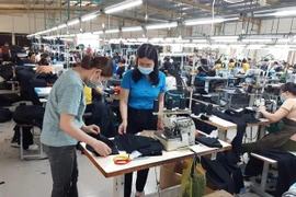 Công nhân Công ty TNHH May Nien Hsing Ninh Bình, khu công nghiệp Khánh Phú, huyện Yên Khánh, Ninh Bình thực hiện nghiêm quy định phòng, chống dịch COVID-19. (Ảnh: Đức Phương/TTXVN)