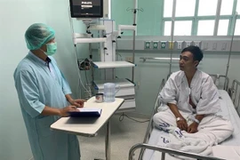 Cán bộ Đại sứ quán thăm hỏi, động viên ngư dân bị thương đang được điều trị tại bệnh viện. (Ảnh: TTXVN phát)