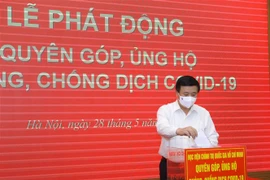 Đồng chí Nguyễn Xuân Thắng, Ủy viên Bộ Chính trị, Giám đốc Học viện Chính trị quốc gia Hồ Chí Minh quyên góp ủng hộ Quỹ phòng, chống COVID-19. (Ảnh: Nguyễn Điệp/TTXVN)
