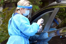 Nhân viên y tế lấy mẫu xét nghiệm COVID-19 cho người dân tại Salo, Phần Lan. (Ảnh: AFP/ TTXVN)