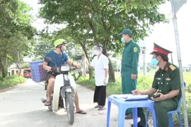 Chốt kiểm soát tiến hành đo thân nhiệt và yêu cầu người dân khai báo y tế tại Hưng Yên. (Ảnh: Đinh Tuấn/TTXVN)