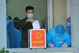 Các cử tri làm nhiệm vụ tại Khu cách ly tập trung, bỏ phiếu bầu tại đơn vị bầu cử số 7, phường Trang Hạ, thị xã Từ Sơn. (Ảnh: Minh Đức/TTXVN)
