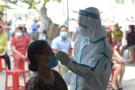 Tiểu thương chợ Phước Mỹ thực hiện xét nghiệm COVID-19. (Ảnh: Văn Dũng/TTXVN)