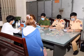 Các lực lượng chức năng thuộc Công an tỉnh Hà Nam phát hiện, lập biên bản xử phạt người vi phạm không đeo khẩu trang nơi công cộng. (Ảnh: Đại Nghĩa/TTXVN)