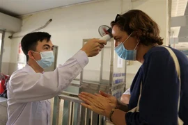 Hành khách được xịt sát khuẩn và đo thân nhiệt trước khi vào bến xe khách ở Hà Nội(ảnh chụp chiều 6/5/2021). (Ảnh: Hoàng Hiếu/TTXVN)