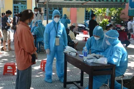 Nhân viên y tế Đà Nẵng điều tra thông tin của người đến lấy mẫu. (Ảnh: Văn Dũng/TTXVN)