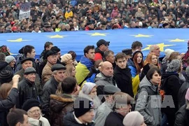 Những người biểu tình giơ cao lá cờ EU khổng lồ trong cuộc biểu tình tại Kiev. (Nguồn: AFP/TTXVN)