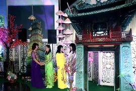 Tà áo dài Việt Nam bên biểu tượng của Hà Nội và Huế. (Ảnh: Trần Quang Vinh/Vietnam+)