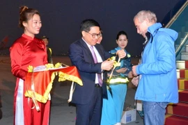 Ông Đỗ Đình Hồng, Giám đốc Sở Du lịch Hà Nội tặng hoa chào đón ông Thomas Bauche. (Ảnh: Kim Chung/TTXVN)