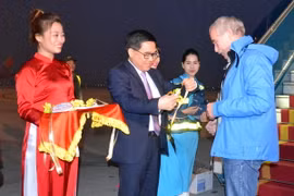 Ông Đỗ Đình Hồng, Giám đốc Sở Du lịch Hà Nội tặng hoa chào đón ông Thomas Bauche. (Ảnh: Kim Chung/TTXVN)
