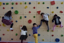 Các bé đang thử sức với mô hình leo núi trong nhà. (Ảnh: Nguyễn Tuyến-Gia Quân/Vietnam+)