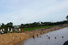 Công tác tìm kiếm thi thể em Huỳnh Tấn Thuận. (Ảnh: Công Mạo/TTXVN)