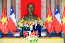 Chủ tịch nước Trần Đại Quang và Tổng thống nước Cộng hòa Chile Michelle Bachelet Jeria ký Tuyên bố chung. (Ảnh: Nhan Sáng/TTXVN)