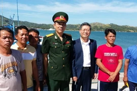 Đại sứ Lý Quốc Tuấn và Đại tá Nguyễn Văn Hùng-Tùy viên quốc phòng tại Philippines (thứ 3 và thứ 4 từ phải sang) gặp gỡ, động viên các ngư dân. (Ảnh: TTXVN)