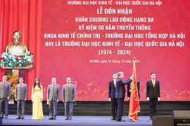 Tổng Bí thư Tô Lâm trao tặng Huân chương Lao động hạng Ba cho Trường Đại học Kinh tế - Đại học Quốc gia Hà Nội nhân dịp kỷ niệm 50 năm ngày thành lập trường. (Ảnh: Thống Nhất/TTXVN)