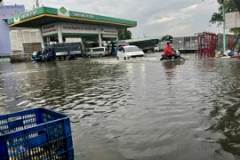 Ngập úng sâu ở cây xăng trên đường Nguyễn Văn Linh, Quận 8. (Ảnh: Thanh Vũ/TTXVN)