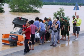 Hành khách được đưa lên canô ra nơi an toàn (ảnh chụp lúc 13 giờ ngày 15/10). (Ảnh: Đức Thọ/TTXVN)