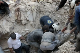 Tình nguyện viên Syria chuyển thi thể một nạn nhân sau một vụ không kích tại Aleppo ngày 4/10. (Nguồn: AFP/TTXVN)