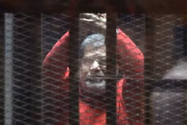 Cựu Tổng thống Mohammed Morsi đứng sau song sắt tại phiên tòa xét xử ông ở Cairo ngày 23/4. (Nguồn: THX/TTXVN)